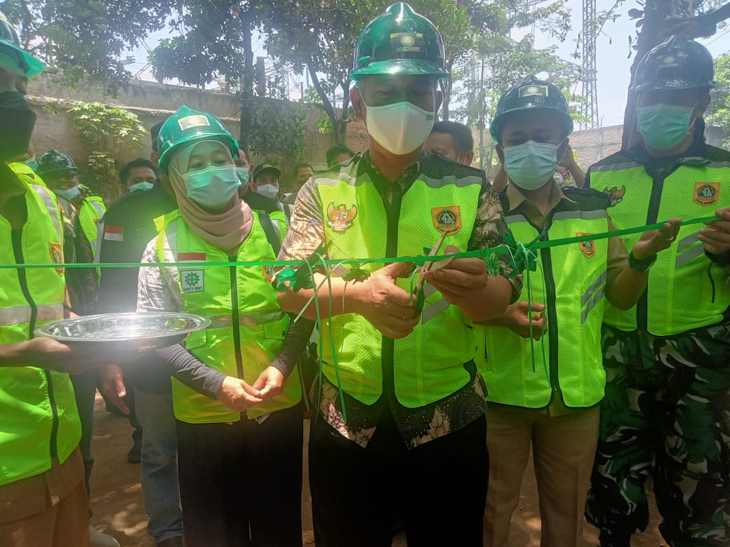 Camat Gunung Putri Didin Wahidin didampingi Kades Cicadas Dian dan Muspika Gunung Putri sedang gunting pita dimulainya proyek Samisade